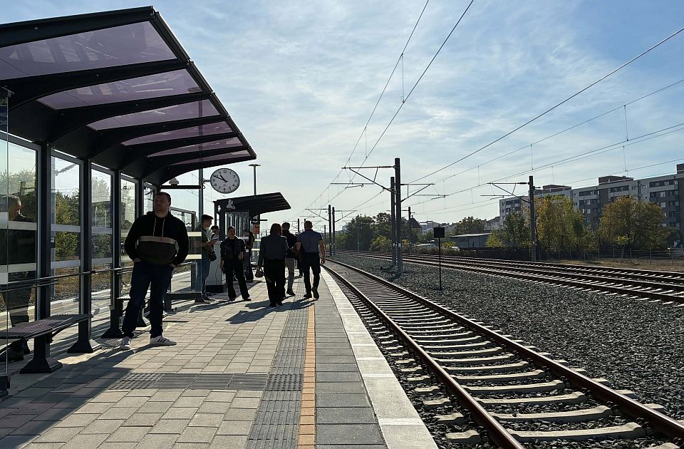 The platform of the TPS Novi Sad stop on Rumenački put: a glass shelter, a clock, passengers waiting for a train