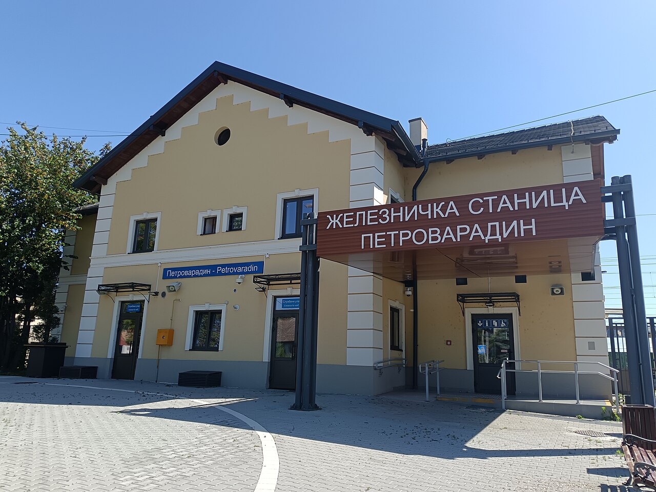 The yellow building of Petrovaradin station with the sign “Železnička stanica Petrovaradin”